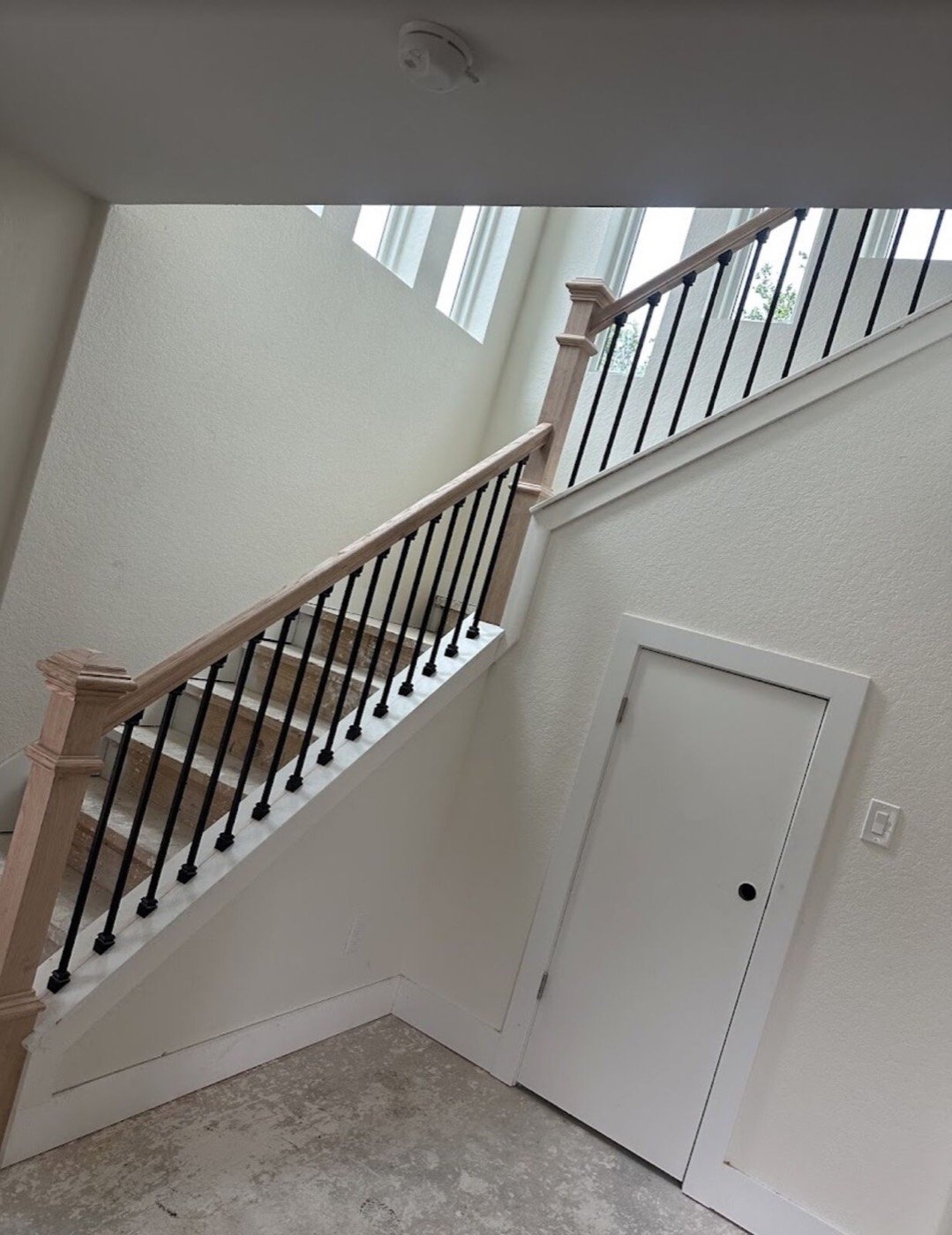 Interior staircase with wood handrail and black metal balusters